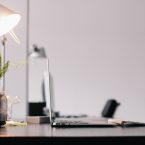 ordinateur macbook posé sur bureau avec lampe et plante