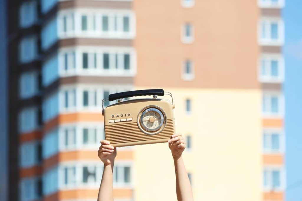 Personne tenant en l'aire une ancienne radio cassette vintage