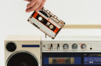 Personne mettant une petite cassette dans une radio ancienne